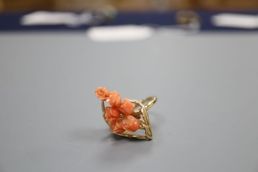 A carved coral mounted ring, stamped 585, finger size M/N